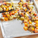 A tray of food with aluminum foil covering vegetables.