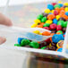 A clear plastic container with colorful candies.