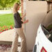 A woman opening a Lifetime almond folding table.