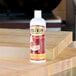 A 16 oz. squeeze bottle of Emmet's Elixir Wood Conditioner on a wooden surface.