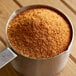 A metal container filled with Regal Bay Seafood Blend, a mixture of brown spices.