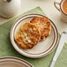 An Acopa brown speckle stoneware plate with pancakes and coffee on it.