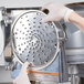 A person wearing gloves using a Hobart 3/16" Shredder Plate on a machine.