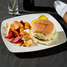 A Fineline plastic plate with a hamburger and fries on it.