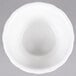 A CAC Bone White China ramekin with a white floral pattern on a gray surface.