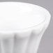 A close up of a CAC Bone White China Floral Ramekin with a rippled edge.