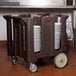 A dark brown Cambro dish cart with plates on it.