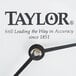 A close-up of a Taylor large dial clock with black hands.
