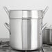 A Vollrath stainless steel stock pot with two lids on top.