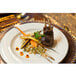A 10 Strawberry Street Gold Line porcelain plate with meat and vegetables on it.