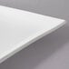 A white square porcelain coupe platter with a curved edge.