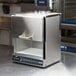 An Amana stainless steel commercial microwave oven with a handle.