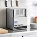 An Amana heavy duty commercial microwave on a kitchen counter.