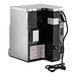 A heavy duty commercial microwave with a stainless steel exterior and attached power cord.