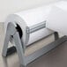 A Bulman paper cutter with a roll of paper on a stand.