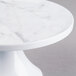 An Elite Global Solutions Sierra marble cake stand with a pedestal and a marble top.