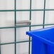 A blue plastic bin sits on a metal grid.