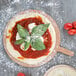 a pizza with basil leaves on top