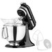 A close-up of a black and silver KitchenAid Artisan tilt-head countertop mixer.