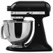 A black KitchenAid Artisan countertop mixer with a silver bowl.