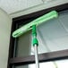 An Unger Micro StripWasher with a green cloth hanging on a window.