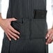 A Chef Revival black and white pinstripe apron with a pocket.