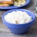 A peacock blue melamine bowl filled with coleslaw on a table.