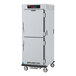 A white metal cabinet on wheels with two doors.
