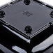 A black square GET Geneva melamine bowl with holes in the top.