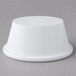 A Carlisle white melamine oval ramekin on a gray surface.