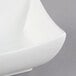 An Arcoroc white square porcelain bowl with a curved edge.