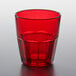 a red glass with a clear liquid inside