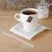A white cup of tea with a Royal Paper wood coffee stirrer on a plate.