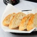 A basket with Hoffmaster linen-feel napkins and a piece of bread on it.