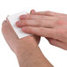 a person wiping their hands with a white napkin
