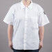 A woman wearing a white Chef Revival short sleeve cook shirt.