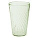 A clear glass with a green liquid in it.