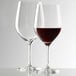 Two Stolzle all-purpose wine glasses filled with red wine.