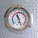 A close-up of a temperature gauge on a metal surface inside a walk-in cooler.