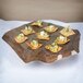 A GET Melamine display tray with crackers, cucumber, and hummus on a table.