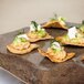 A GET Melamine Stone Display Tray with small appetizers on a table.