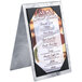 A Menu Solutions Alumitique menu tent holding a menu on a metal stand.
