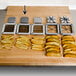 A white cutting board with a variety of french fries and potato wedges.