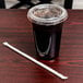 A plastic cup with a lid and a green and white Eco-Products wrapped straw next to it.