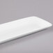 A CAC white rectangular porcelain platter on a gray surface.