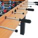 An American Legend foosball table with soccer balls on it.