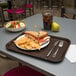 A Carlisle fast food tray with a sandwich, chips, and a drink on it.