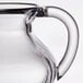 A clear plastic creamer with a handle.