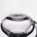 A clear plastic creamer with a handle on top.