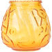 A yellow glass Sterno Venetian candle holder with a design on it.